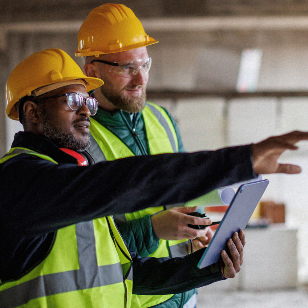 Two male property developers collaborating on a project, reviewing its performance and progress