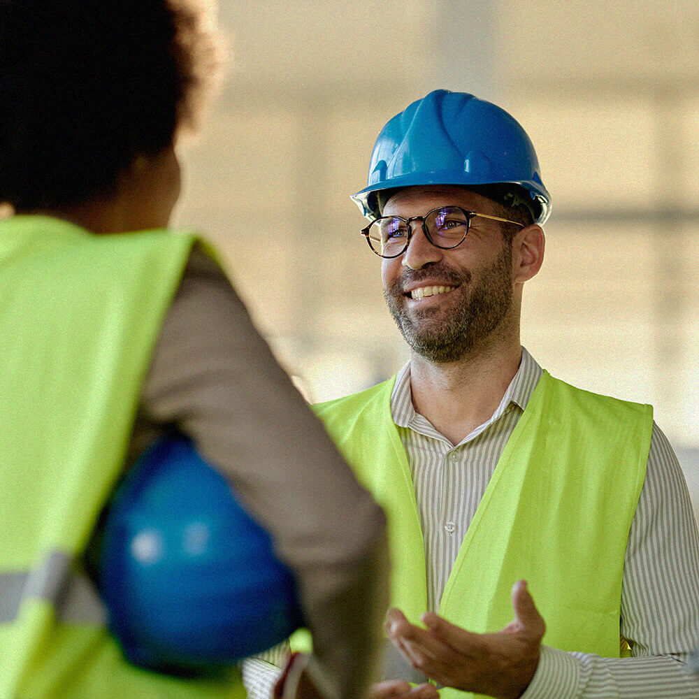 Developer wearing hard hat and high-visibility vest on construction site